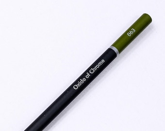 May include: A sharpened colored pencil with a black barrel and an olive green end cap. The text "Oxide of Chrome" is printed in white along the side, and the number "063" is printed in white on the olive green section of the pencil barrel.