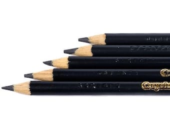 May include: A close-up of a set of black pencils with sharpened tips. The pencils are arranged in a diagonal line, with the tips pointing towards the left. The pencils have gold lettering and are set against a white background.