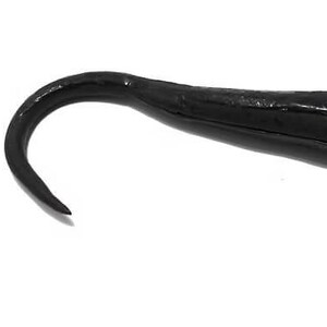 May include: A black fishing lure with a curved tail and a hollow body. The lure is designed to mimic a baitfish and has a smooth, glossy finish. The hook is not visible in the image.