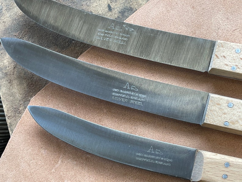 Może przedstawiać: Trzy noże ze srebrnej stali z drewnianymi rękojeściami. Noże są oznaczone "Geo. Barnley & Sons Sheffield, England Silver Steel".