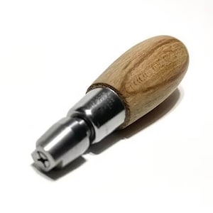 May include: A wooden and metal bottle stopper. The handle is made of light brown wood with a rounded shape. The metal portion is silver and has a star-shaped design on the end.