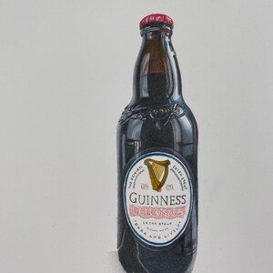 May include: A dark stout Guinness beer bottle with a red cap. The label reads "Guinness Original Extra Stout" with a gold harp emblem. The bottle is dark with a glossy finish.