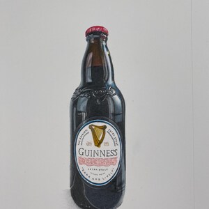 May include: A dark glass Guinness beer bottle with a red cap. The label features a gold harp and the words "Guinness Original Extra Stout". The bottle is filled with a dark liquid.