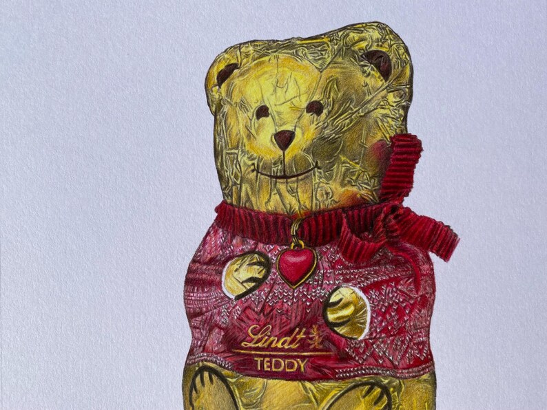 Puede incluir: Ilustraci&oacute;n detallada de un oso de peluche Lindt. El oso est&aacute; envuelto en papel dorado y lleva un su&eacute;ter rojo con un colgante de coraz&oacute;n. El texto "Lindt TEDDY" es visible en el su&eacute;ter.