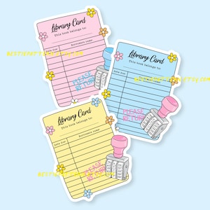 May include: Three colorful library card stickers in pink, blue, and yellow, each with a floral design and the text "Library Card." Each sticker has a date due section and a borrower's name section. A pink stamp is next to each card.
