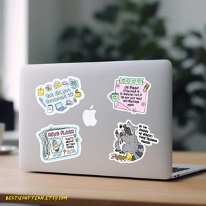 May include: Laptop covered in colorful stickers. Stickers include text: "But did you document it?", "On Break! I'll be back in 15 minutes", "NEWS FLASH That's above my pay grade", and "BE THE REASON HR UPDATES THEIR TRAINING MANUAL".