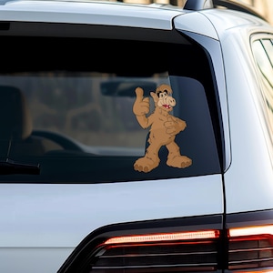 Puede incluir: Un personaje de dibujos animados marr&oacute;n y beige con una nariz grande y una gran sonrisa da un pulgar hacia arriba. El personaje est&aacute; en la ventana de un coche blanco.