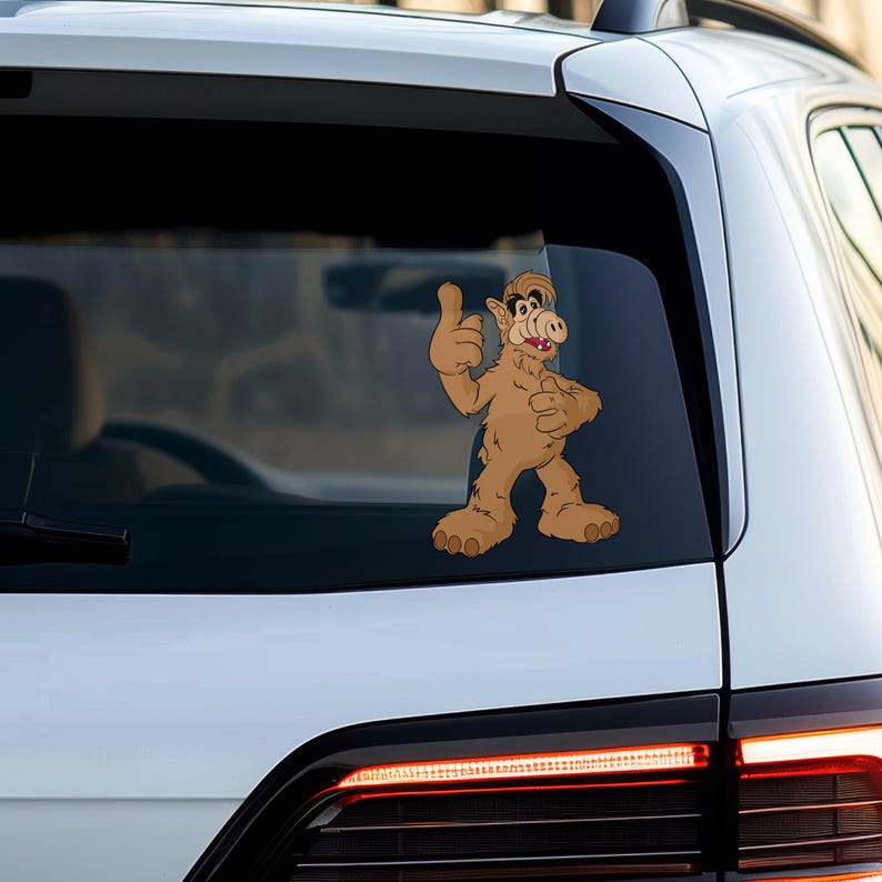 Puede incluir: Un personaje de dibujos animados marr&oacute;n y beige con una nariz grande y una gran sonrisa da un pulgar hacia arriba. El personaje est&aacute; en la ventana de un coche blanco.