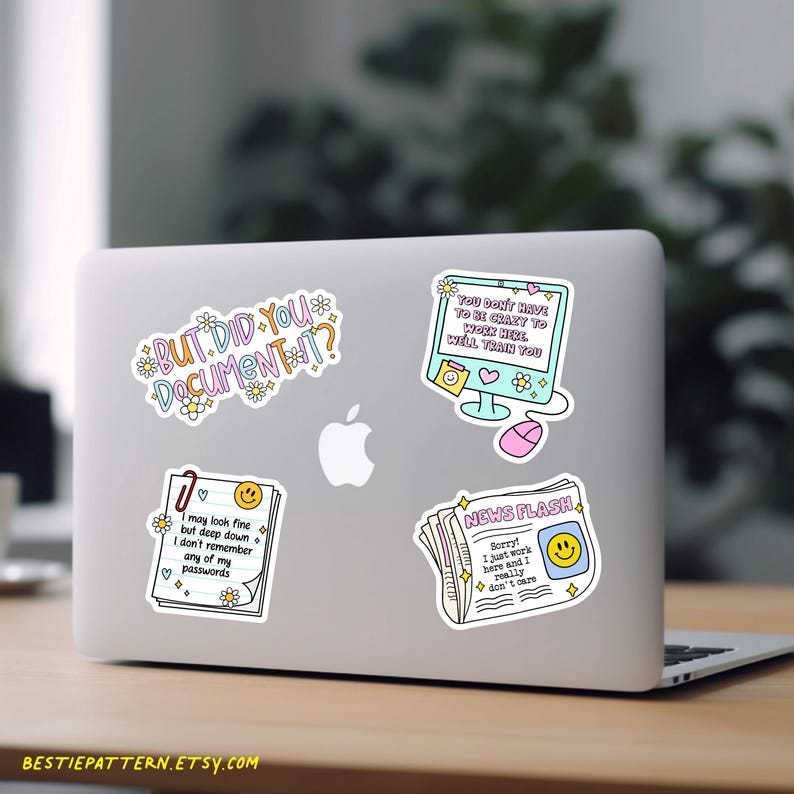 Puede incluir: Un port&aacute;til con cuatro pegatinas coloridas. Las pegatinas tienen textos humor&iacute;sticos: "BUT DID YOU DOCUMENT IT?", "YOU DON'T HAVE TO BE CRAZY TO WORK HERE, WELL TRAIN YOU", "I may look fine but deep down I don't remember any of my passwords", y "NEWS FLASH".