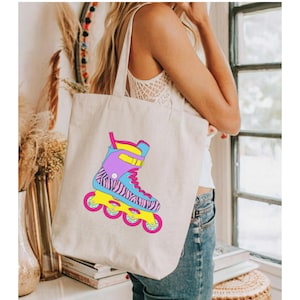 May include: A white canvas tote bag with a colorful illustration of a roller skate. The skate has a zebra print design and pink, blue, and yellow accents.