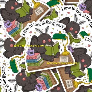 May include: A collection of stickers featuring a cartoon moth reading books at a library. The moth is black with pink eyes and is surrounded by books, a lamp, and the text "I love to lurk at the library". The stickers have a whimsical, bookish theme.