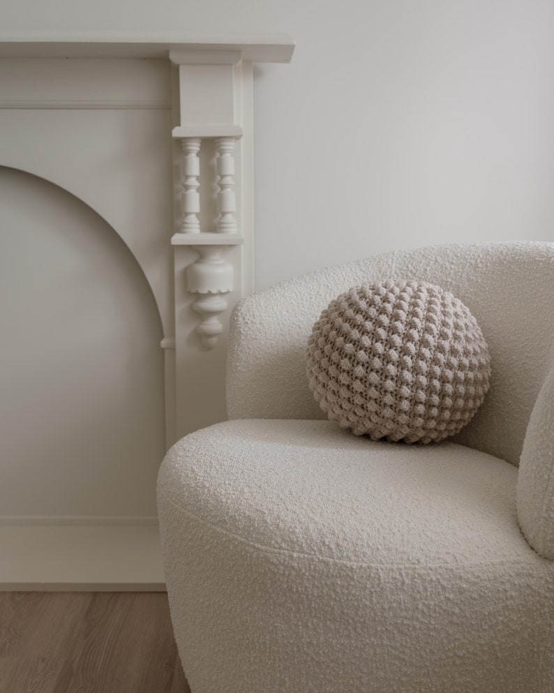 Handmade crochet bobble ball cushion in a round shape, featuring a textured bobble stitch pattern.