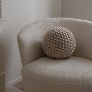 Handmade crochet bobble ball cushion in a round shape, featuring a textured bobble stitch pattern.