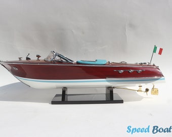 May include: A mahogany speedboat model with a white hull and a turquoise interior. The model is on a black stand and has an Italian flag on the back.