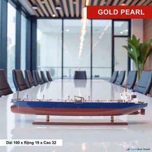 Pode incluir: Modelo de navio com casco vermelho e parte superior azul, montado em um suporte de madeira. O modelo é rotulado como "GOLD PEARL" e mede aproximadamente 100 cm de comprimento, 19 cm de largura e 32 cm de altura.
