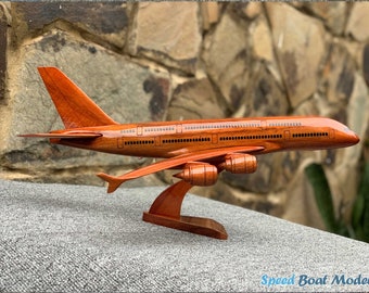 Può includere: Un modello in legno di un aereo Airbus A380, dipinto in un ricco colore mogano. Il modello è esposto su un supporto in legno e presenta dettagliate marcature.