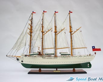 Può includere: Modello dettagliato di una nave alta a quattro alberi, con vele bianche e scafo verde. La nave ha un corpo bianco con finiture verdi ed è montata su una base di legno. La bandiera cilena è esposta a poppa. Il modello è una replica dell'Esmeralda.