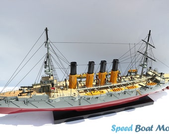 May include: A detailed model of a grey and red ship with four black and yellow smokestacks. The ship has a wooden deck and is on a black display stand. The model is labeled "Speed Boat Model".