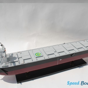 Puede incluir: Modelo detallado de un carguero, con cubierta gris, casco negro con línea de flotación roja y superestructura blanca. El modelo está montado sobre un soporte negro. El texto "Speed Boat Model" es visible.