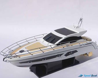 Può includere: Un modello di yacht bianco e nero con una base nera. Lo yacht ha uno scafo bianco con accenti neri e un parabrezza nero. Lo yacht è su una base nera con un'etichetta bianca che dice "Speed Boat Model".