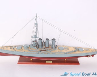 May include: A detailed model of the HMS Tiger warship, featuring a gray hull, wooden deck, and multiple turrets. The model includes a British flag and is mounted on a wooden base. The model is approximately 30 inches long.