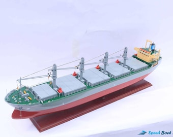 May include: A detailed model of a gray and red cargo ship with multiple cranes and a yellow and blue superstructure. The ship is displayed on a wooden base.