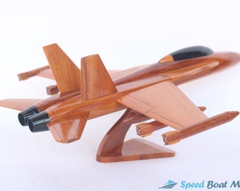 May include: A wooden model of a fighter jet with black accents on the cockpit and engines. The model is mounted on a wooden stand and has two missiles attached to the wings.