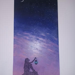 Könnte beinhalten: Vertikales Gemälde, das einen Nachthimmel mit einem Halbmond und Sternen zeigt. Eine Silhouette einer Person, die eine Laterne hält, sitzt auf einer Felsformation. Der Himmel geht von Dunkelblau in Violett über.