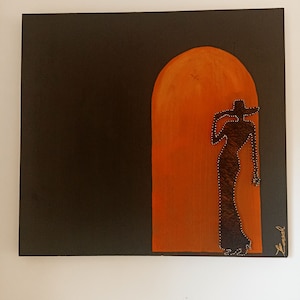 Könnte beinhalten: Abstraktes Gemälde auf Leinwand. Das Kunstwerk zeigt einen dunklen Hintergrund mit einem orangefarbenen Torbogen. Eine Silhouette einer Person in Kleid und Hut ist im Torbogen dargestellt, erstellt mit String-Art-Technik.