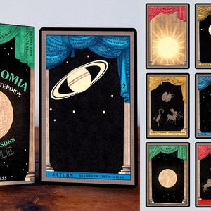 May include: A deck of oracle cards with a black background and gold accents. The cards feature illustrations of planets and celestial bodies. The box features the title "Astronomia Planets & Asteroids A Four Seasons Oracle" and the publisher "Urania Press".