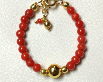 Puede incluir: Una pulsera de cuentas rojas con detalles dorados. La pulsera presenta pequeñas cuentas rojas redondas y cuentas doradas. Tiene un cierre dorado y un dije decorativo. Diseñada para la muñeca.