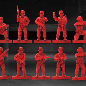 May include: Ten red plastic toy soldiers in various poses, holding rifles and standing on a grey surface.