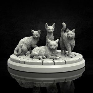 May include: Four grey, ceramic cat figurines are posed on a circular base. The cats are in various positions, including sitting, lying down, and standing. The base is made of a textured material that resembles stone.