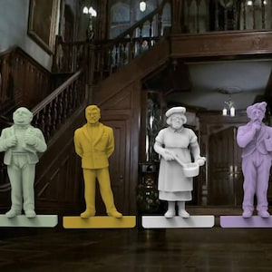 May include: Six colourful figurines of characters, each standing on a rectangular base. The figures are in various colours, including pink, green, yellow, white, purple, and blue. The background is a dimly lit room with a staircase.
