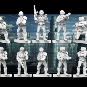 Peut inclure: Dix figurines miniatures en plastique blanc de soldats en armure futuriste, tenant des armes, debout sur une surface noire.