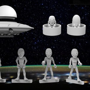 May include: A set of grey plastic alien figurines, including a flying saucer, a group of aliens holding weapons, and a few aliens in pods. The aliens have large heads, big eyes, and small mouths.