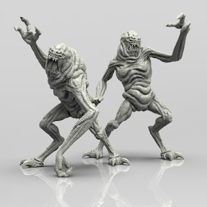 May include: Two grey, detailed, 3D printed figures of a creature with a large mouth and sharp claws. The figures are posed in a dynamic, action-ready stance.