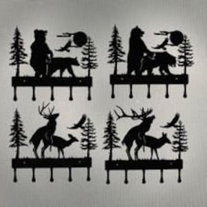 May include: Set of four black metal wall hooks featuring silhouette designs of a bear, deer, and a wolf. Each hook has five prongs for hanging items.