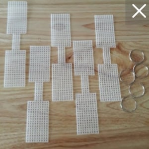 May include: Eight white plastic canvas sheets with a hole in the center, and six silver jump rings.