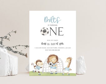 May include: A blue and white soccer-themed birthday invitation for a boy named Miles turning one. The invitation features a soccer ball, a lion, a monkey, and a giraffe playing soccer. The text on the invitation reads "Miles is turning One" and "May 20, 2023 at 2pm".