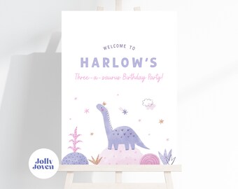 May include: A white welcome sign with purple text that reads "Welcome to Harlow's Three-a-saurus Birthday Party!"  A purple dinosaur with a crown is standing on a pink and purple landscape.