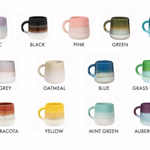 May include: Twelve ceramic mugs in various colors, each with a gradient glaze effect. The mugs are arranged in four rows of three, with the colors of the mugs in each row being similar. The colors of the mugs are lilac, black, pink, green, teal, grey, oatmeal, blue, grass green, terracotta, yellow, mint green, and aubergine.