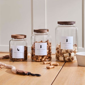 May include: Three glass jars with wooden lids, filled with pet food and treats. The jars are labelled "Merlin's Food", "Rolo's Treats", and "Luna's Treats".