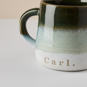May include: A green and white ceramic mug with a handle. The mug has a gradient of green to white and is personalized with the name "Carl."