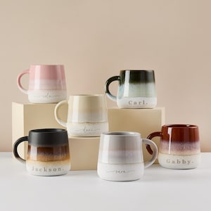 May include: Six ceramic mugs with ombre glaze in various colors. Each mug has a name written on the bottom in a cursive font. The names are: Lola, Dani, Carl, Jackson, Nara, and Gabby.