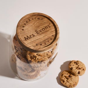 Peut inclure: Un bocal en verre avec un couvercle en bois rempli de biscuits aux p&eacute;pites de chocolat. Le couvercle porte la mention "BREAKTIME" et "Mrs. Evans" grav&eacute;e.