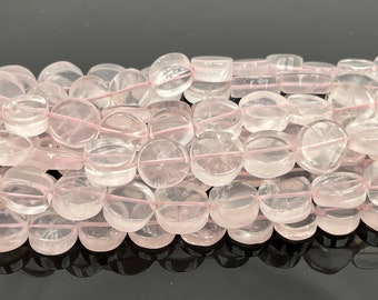May include: A strand of pale pink rose quartz beads, each bead is a flat, round disc with a slightly irregular shape. The beads are strung on a thin, clear elastic cord.