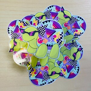 May include: A collection of stickers featuring a cartoon turtle wearing sunglasses. The turtle is light green with a light blue shell decorated with geometric shapes, including triangles, checkered patterns, and purple and pink accents.