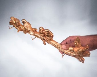 May include: Gold-toned metal bird hook rack with four bird figurines and hooks. The rack is shaped like a branch.