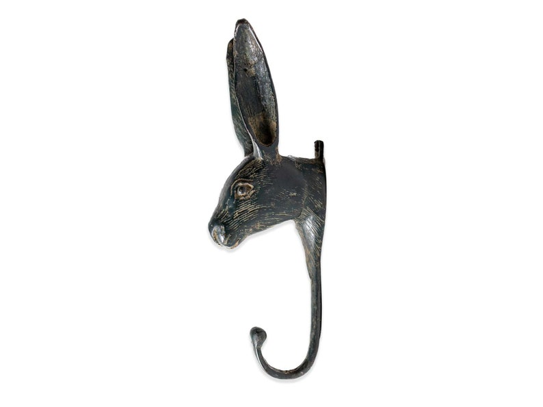 May include: Black metal rabbit head hook with a distressed finish. The hook is shaped like a rabbit's head with long ears and a curved hook.